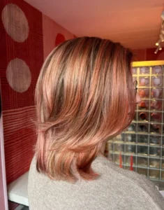 Vrouw met lichtrode tint in het haar door Creative Coloring bij de Colorbar Twiggy&James in Alkmaar