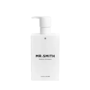Witte pompflacon van Mr. Smith Restore Shampoo van 275 ml tegen een zwarte achtergrond.