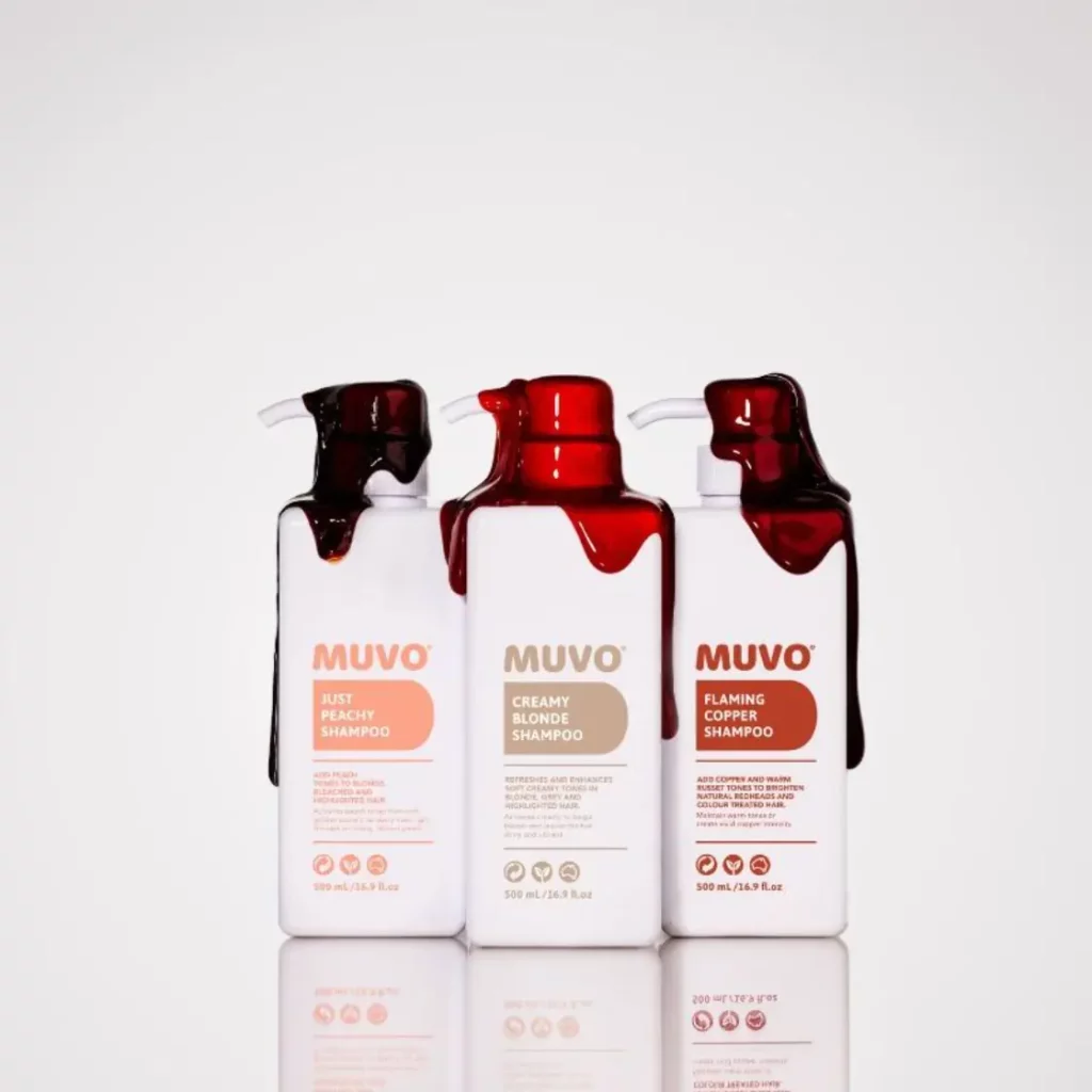 Drie flessen MUVO salonkwaliteit shampoo met rode vloeistof die van de bovenkant druipt.