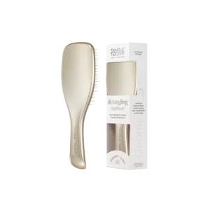 Goudkleurige Tangle Teezer ontklittende haarborstel naast bijpassende verpakking.
